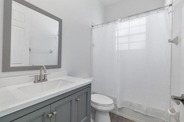 full bathroom featuring toilet, vanity, shower / tub combo, and hardwood / wood-style floors