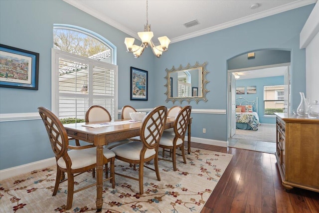 dining space featuring an inviting chandelier, ornamental molding, and hardwood / wood-style floors