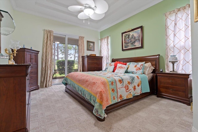 carpeted bedroom featuring ceiling fan, access to exterior, crown molding, and a tray ceiling