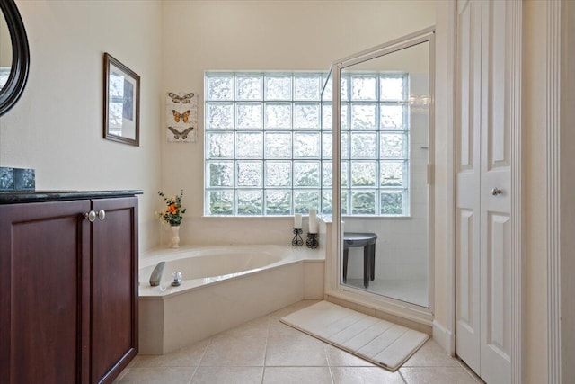 bathroom featuring plenty of natural light, separate shower and tub, and tile patterned flooring