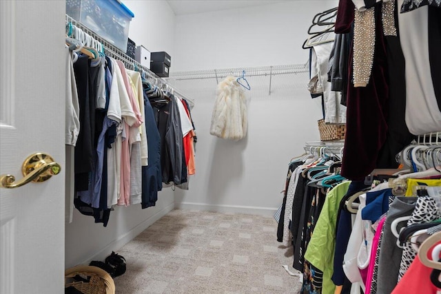 walk in closet with light colored carpet