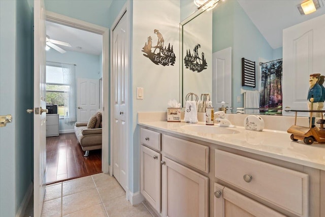 bathroom featuring ceiling fan, vanity, lofted ceiling, and tile patterned flooring