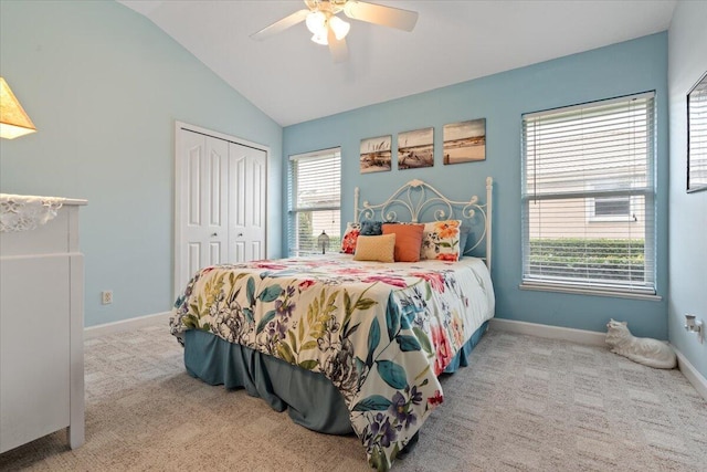 bedroom with ceiling fan, a closet, light carpet, and vaulted ceiling