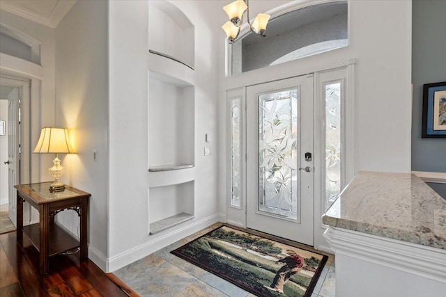 entrance foyer featuring an inviting chandelier and crown molding