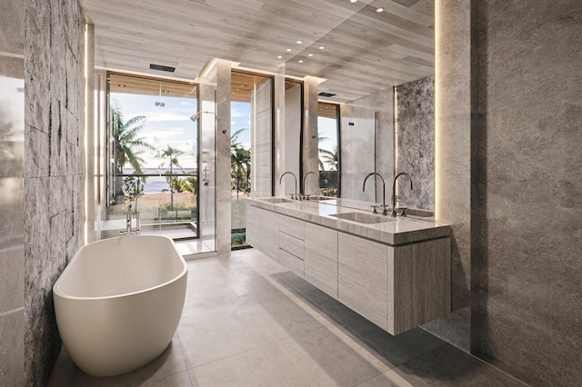 bathroom featuring a tub to relax in, vanity, and floor to ceiling windows