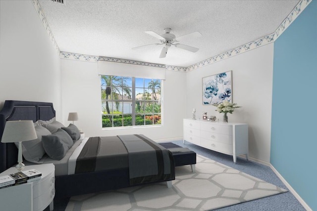 carpeted bedroom featuring a textured ceiling and ceiling fan