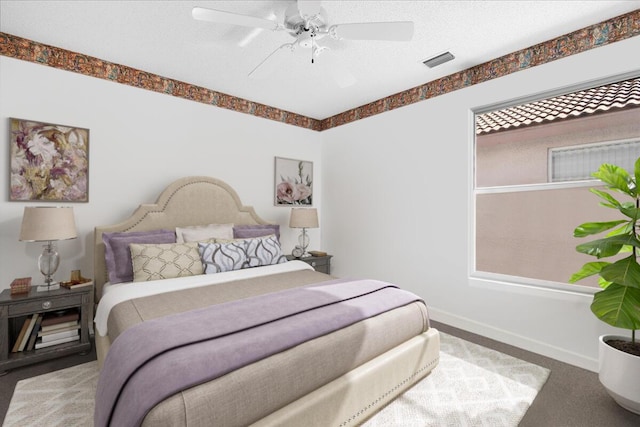 bedroom with ceiling fan, a textured ceiling, and carpet flooring