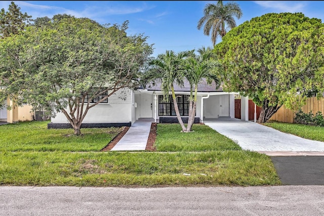 view of front of home with driveway, fence, an attached carport, and a front yard