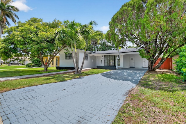 2112 N 14th Ter, Hollywood, FL 33020 - view of front of property with decorative driveway, a carport, and stucco siding