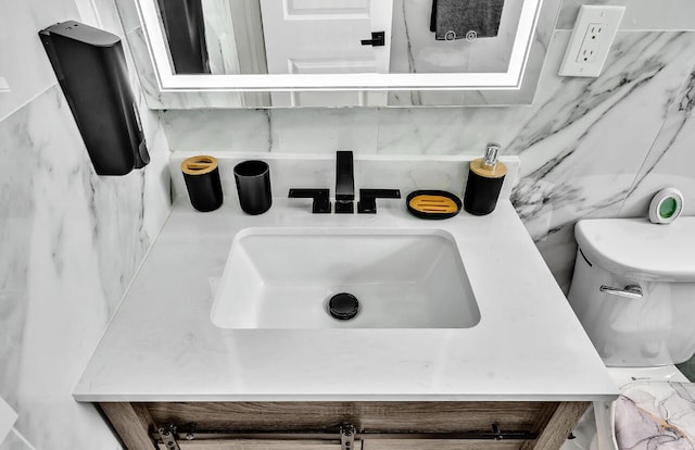 bathroom featuring toilet, backsplash, and sink