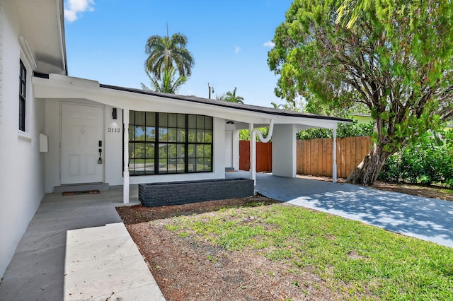 2112 N 14th Ter, Hollywood, FL 33020 - view of front of home with driveway, stucco siding, and an attached carport