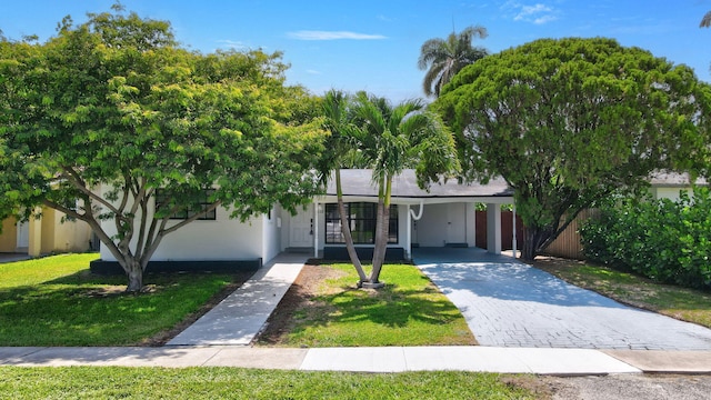2112 N 14th Ter, Hollywood, FL 33020 - view of front of property featuring a carport, driveway, a front yard, and stucco siding