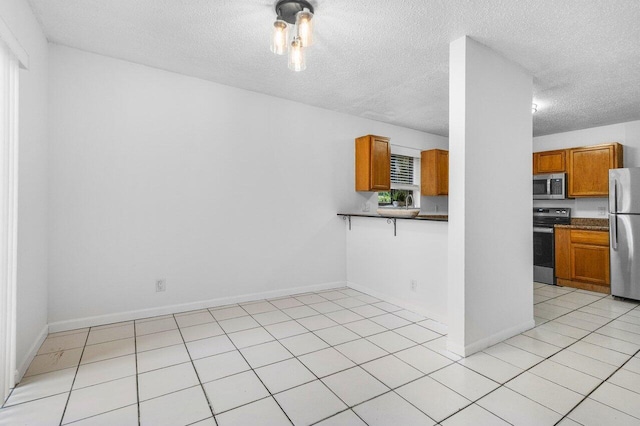 kitchen with a textured ceiling and stainless steel appliances