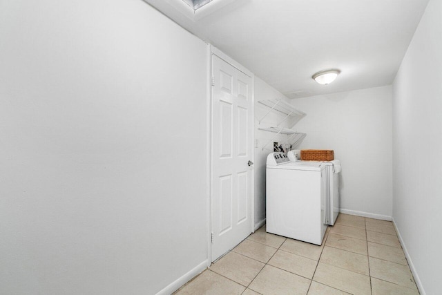 laundry room with light tile patterned floors and washer and clothes dryer