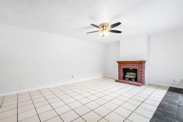 unfurnished living room featuring a brick fireplace, a textured ceiling, light tile patterned floors, and ceiling fan