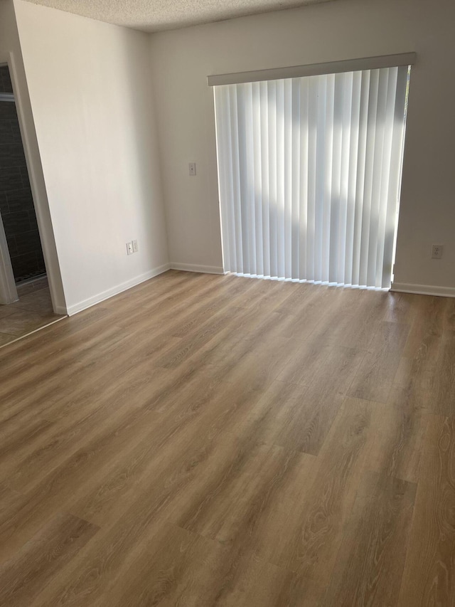 spare room featuring hardwood / wood-style floors and a textured ceiling