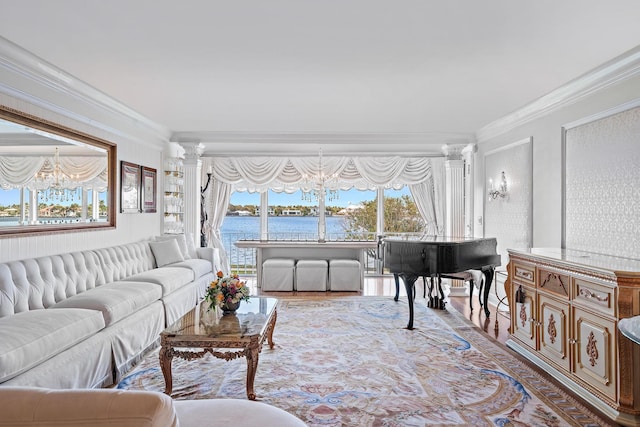 living room with a water view, crown molding, light hardwood / wood-style floors, and decorative columns