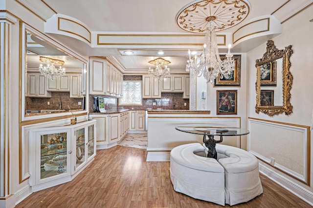 kitchen featuring cream cabinetry, decorative backsplash, and a notable chandelier