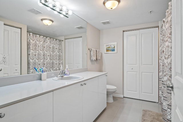 bathroom featuring toilet, vanity, and tile patterned flooring