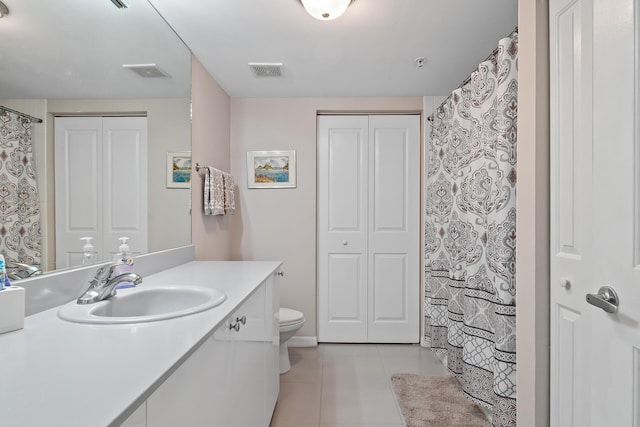 bathroom featuring toilet, vanity, and tile patterned flooring