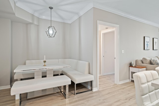 dining area with ornamental molding and light wood-type flooring