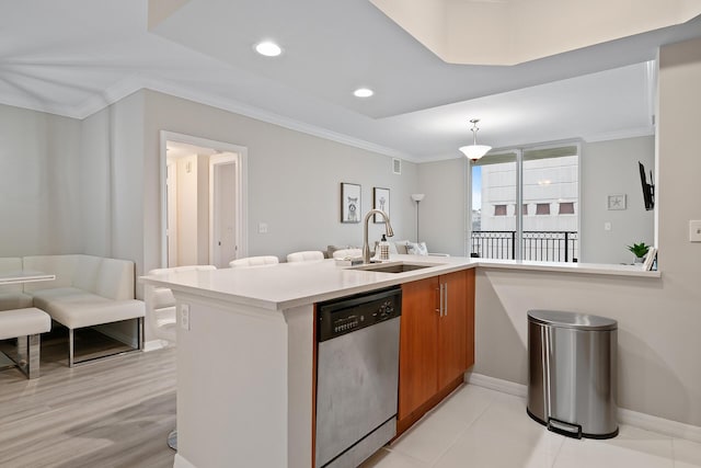 kitchen featuring kitchen peninsula, decorative light fixtures, dishwasher, ornamental molding, and sink