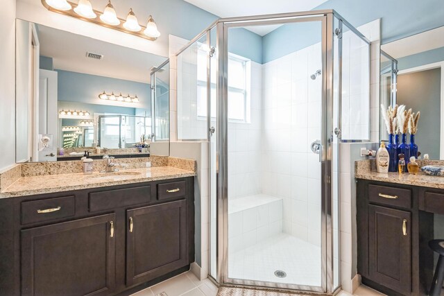 bathroom with vanity, tile patterned floors, and a shower with door