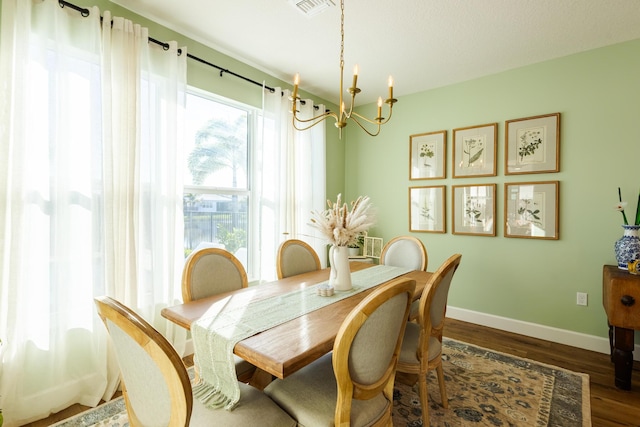 dining space with dark hardwood / wood-style flooring and a notable chandelier