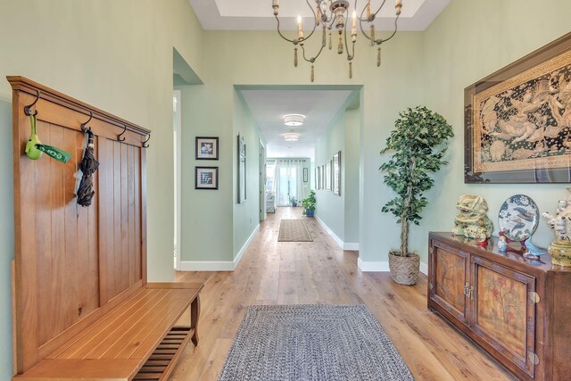 hall featuring light hardwood / wood-style flooring and a notable chandelier