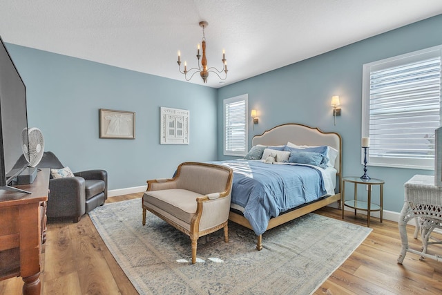 bedroom featuring light hardwood / wood-style floors and a notable chandelier