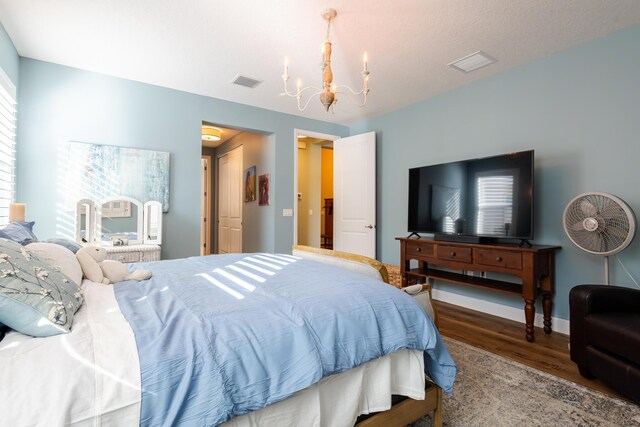 bedroom featuring an inviting chandelier and hardwood / wood-style flooring