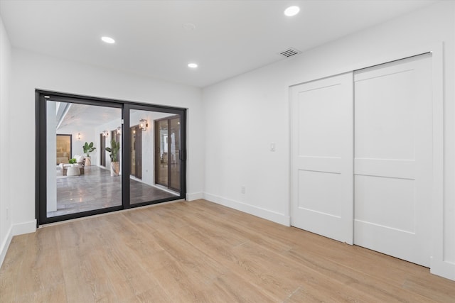 unfurnished bedroom featuring light hardwood / wood-style floors and a closet