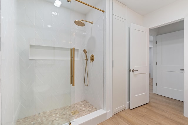 bathroom featuring a shower with door and hardwood / wood-style flooring