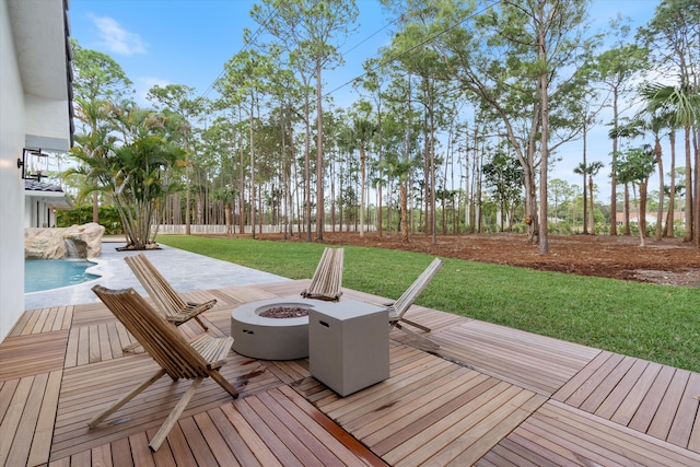 wooden terrace featuring a fenced in pool, a patio area, a lawn, and a fire pit