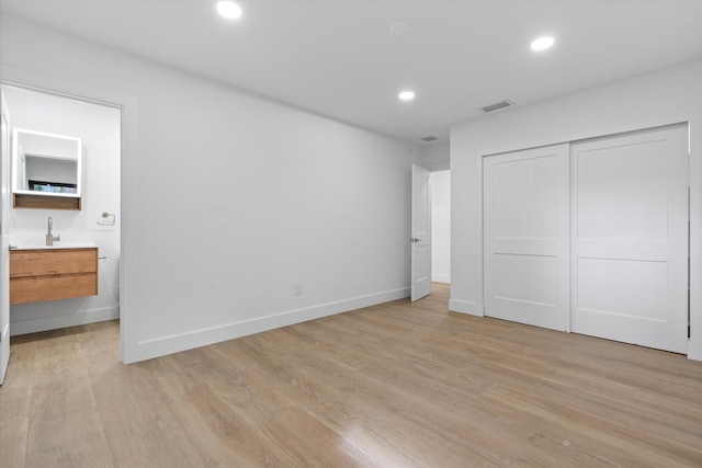 unfurnished bedroom featuring light wood-type flooring and a closet