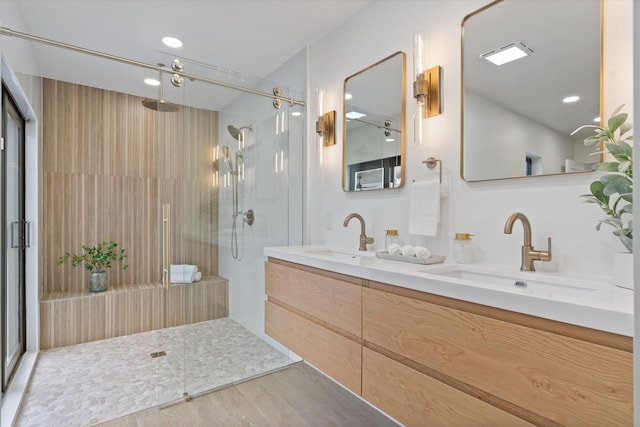 bathroom with vanity, wood-type flooring, and a tile shower