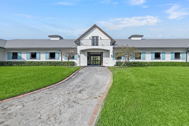 view of front facade with a balcony and a front lawn