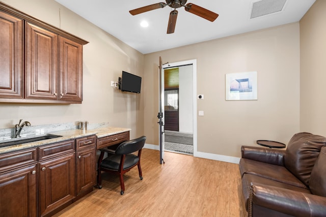 office area with sink, light hardwood / wood-style floors, and ceiling fan