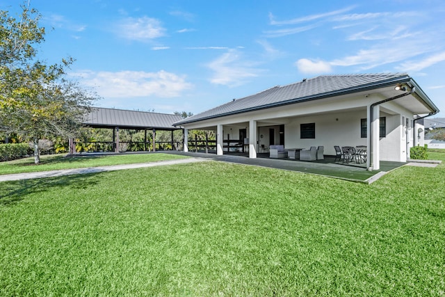 back of house with a lawn and a patio