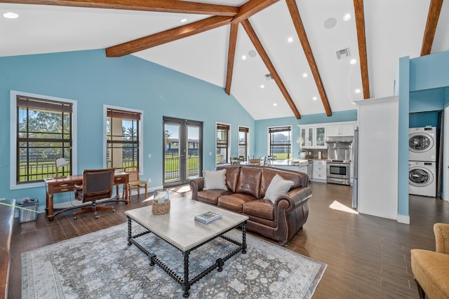 living room with stacked washing maching and dryer, plenty of natural light, high vaulted ceiling, and french doors