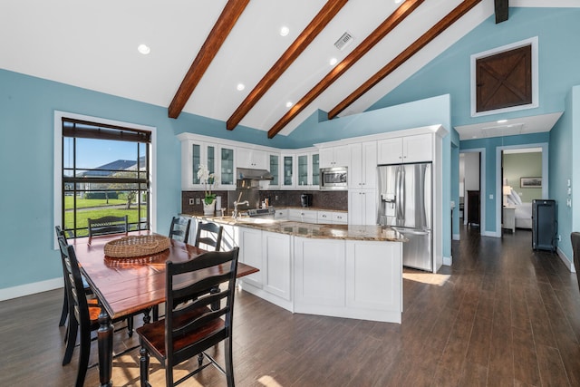 kitchen with appliances with stainless steel finishes, white cabinetry, stone countertops, dark hardwood / wood-style flooring, and decorative backsplash