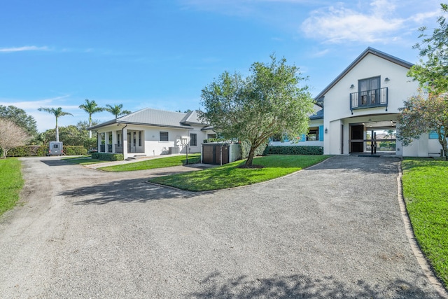 view of front of property featuring a front yard and a balcony