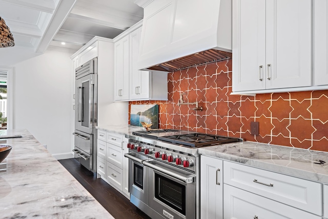 kitchen with light stone counters, premium appliances, custom exhaust hood, and white cabinets