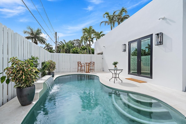 view of pool featuring a patio area and french doors