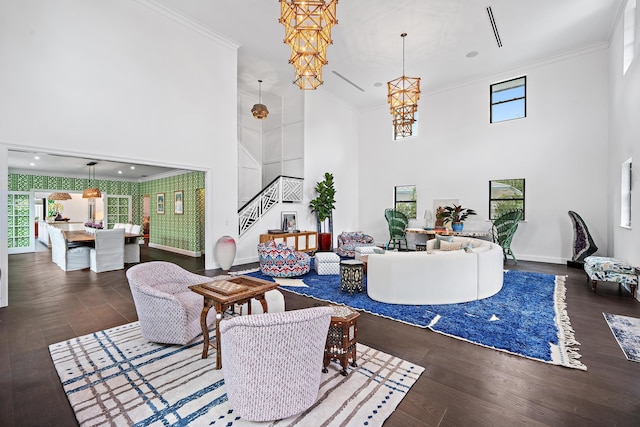 living room featuring an inviting chandelier, ornamental molding, and dark wood-type flooring