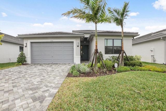 single story home featuring stucco siding, decorative driveway, a front yard, and an attached garage