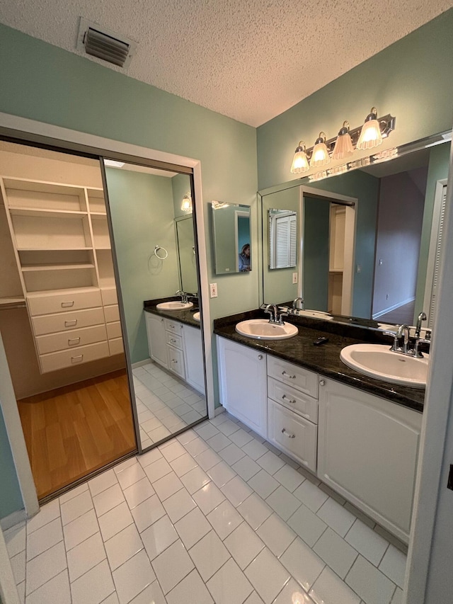 bathroom featuring a textured ceiling, vanity, and tile patterned flooring