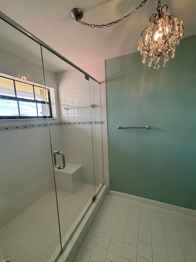 bathroom with tile patterned flooring, walk in shower, and an inviting chandelier