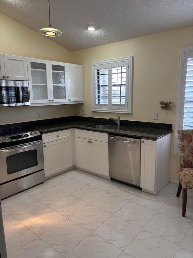 kitchen featuring hanging light fixtures, white cabinets, and stainless steel appliances