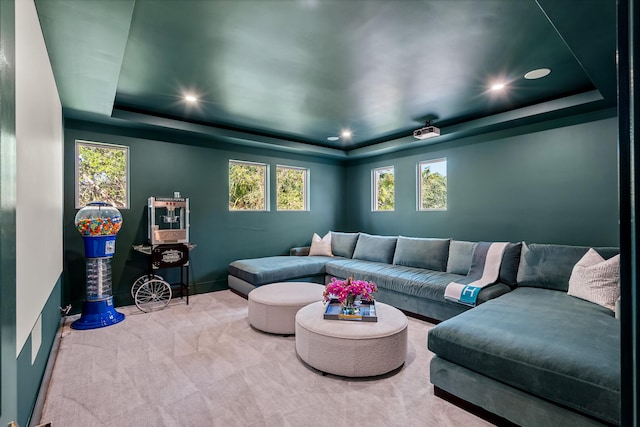 home theater room with carpet flooring and a tray ceiling